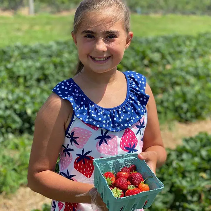 Girl hold package of strawberries